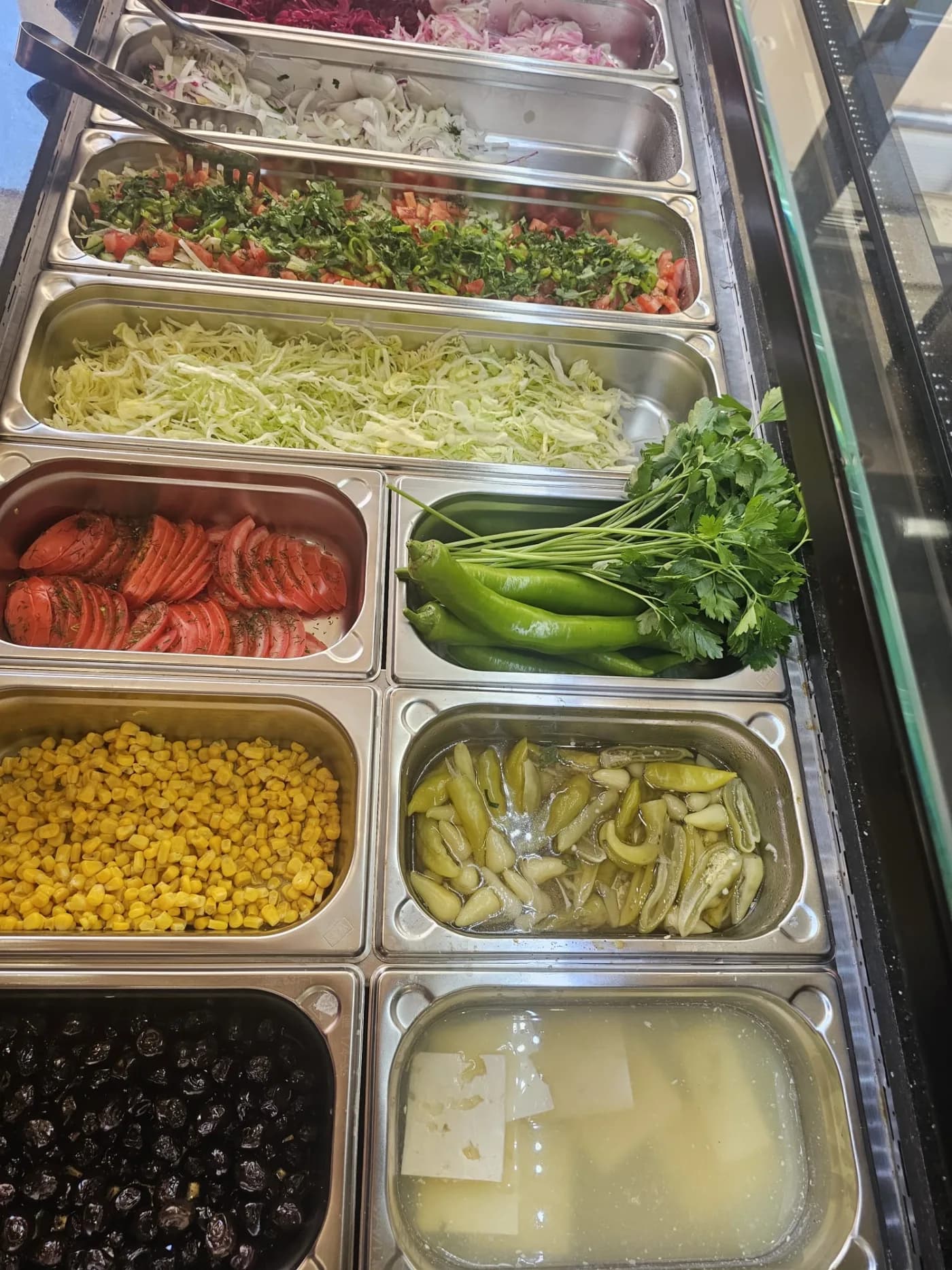 Frische Salate, Kräuter und Gemüse an der Theke